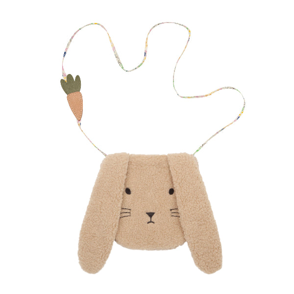 A soft, fluffy bunny-shaped crossbody bag in beige sherpa fabric, featuring an embroidered bunny face with long, floppy ears. The bag has a thin floral fabric strap with a small, decorative faux-leather carrot charm attached. A charming and playful accessory, perfect for children or Easter-themed outfits
